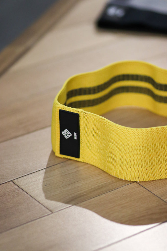 Yellow hip band by Agu Athletics showing rubber threads on the inner side and rubber lion logo tag